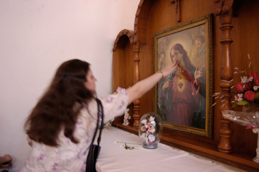 An Iraqi woman touches a portrait of Jesus at St. Joseph's Chaldean Church, Baghdad