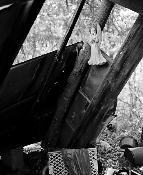 Garbage angel, Liberty, West Virginia (photo of ceramic angel hanging on shed, seeming to fly over a pile of garbage)