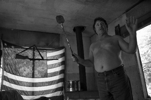 Eric 'Crow' Burgess with weapons (flyswatter and rifle), Liberty, West Virginia