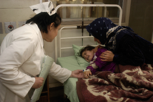 Rasmeyah (left) comforts Murtava Riad, a 4-year-old Hodgkin's lymphoma patient at Sadaam Pediatric Hospital, Baghdad (2003)